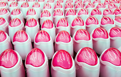 Preview: Deodorant, bottles with pink lids in a row.