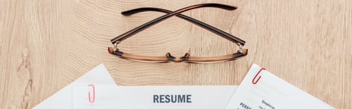 Preview: panoramic shot of print resume templates and glasses on wooden table