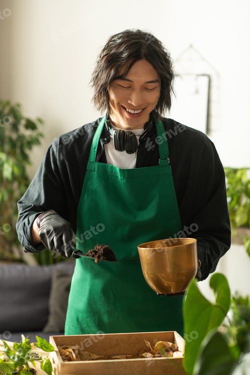 Preview: Joyful young florist tending to plants in a bright shop filled with greenery and life