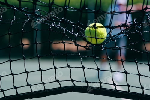 Preview: Thats a lost point. Cropped shot of a tennis ball hitting a tennis net on the court during the day.