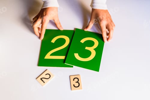 Preview: Hands of a montessori teacher guide presenting how to make sums.