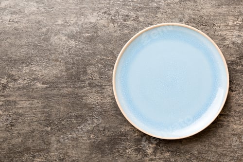 Preview: Top view of empty blue plate on cement background. Empty space for your design