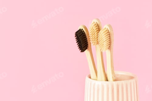 Preview: Bamboo Toothbrushes in Holder Against Pink Background