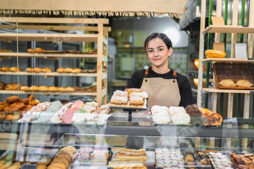 Preview: Pastry chef arranging delicious pastries in bakery display case
