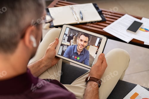 Preview: Businessman doing video call with colleague from home