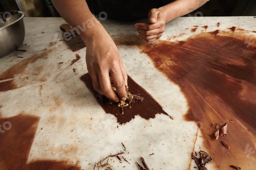 Preview: Close up professional black man chef hands cook circles from melted homemade chocolate