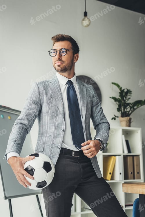 Preview: young handsome businessman with soccer ball at office