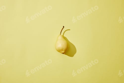 Preview: top view of single fresh ripe pear on yellow background