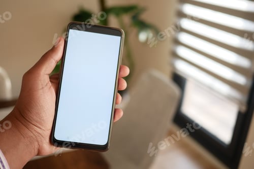 Preview: A hand holds a smartphone in a modern home interior, highlighting technology and lifestyles