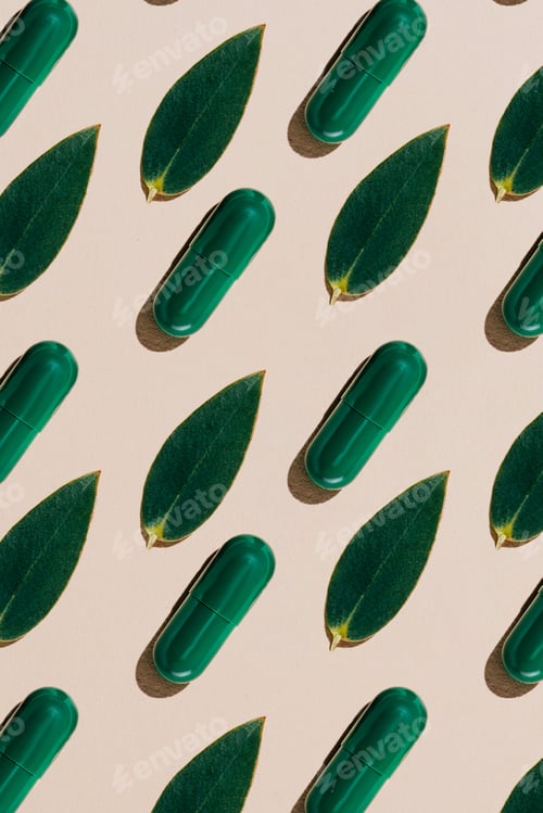 Preview: top view of phytotherapy pills with green leaves in rows pattern on beige surface