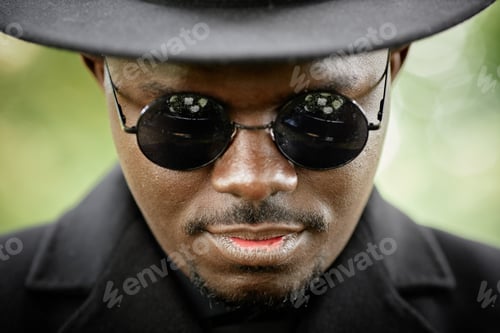 Preview: African American man wearing black hat and sunglasses