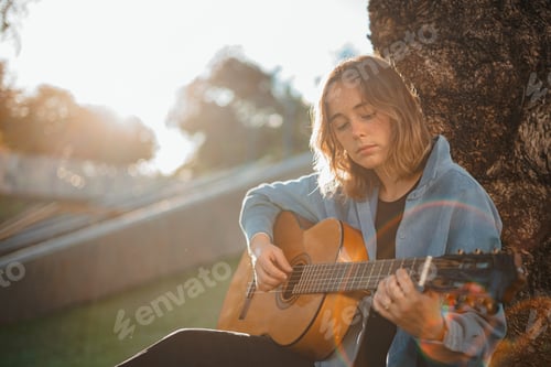 Preview: Girl focus playing the guitar at the park