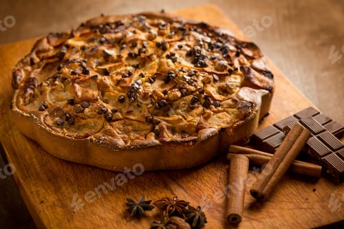 Preview: apple cake with cinnamon stick and chocolate over wood