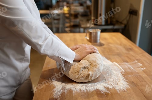 Preview: Baking process, closeup baker hands kneading dough on table