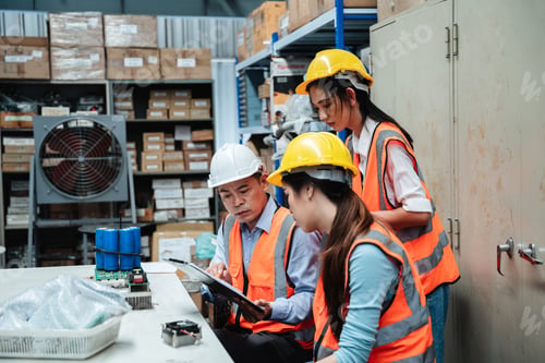 Preview: Warehouse workers checking details work on a tablet in the background warehouse.