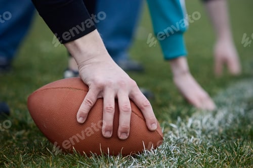 Preview: Close up of a hand holding an oval football on the line, during a game of non-contact flag football.