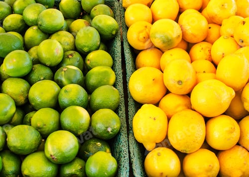 Preview: Overhead shot of colorful green limes and yellow lemons at the grocery store, food shopping