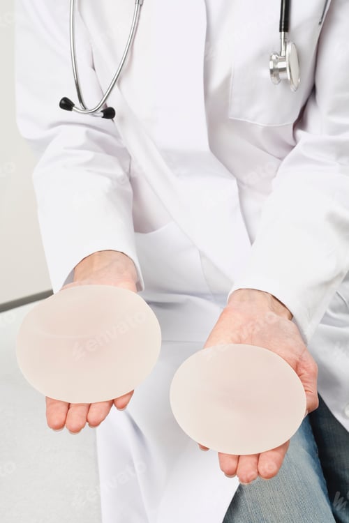 Preview: Germany, Munich, Doctor holding breast implant, close up