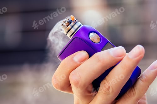 Preview: purple vape in a man's hand on a modern background