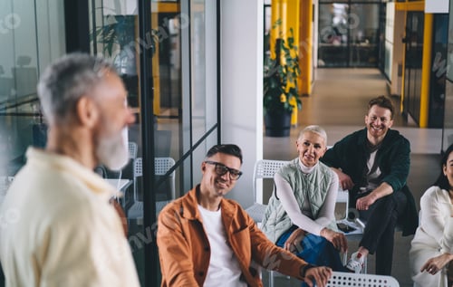 Preview: Team leader speaking about new business strategy with colleagues at workplace in office