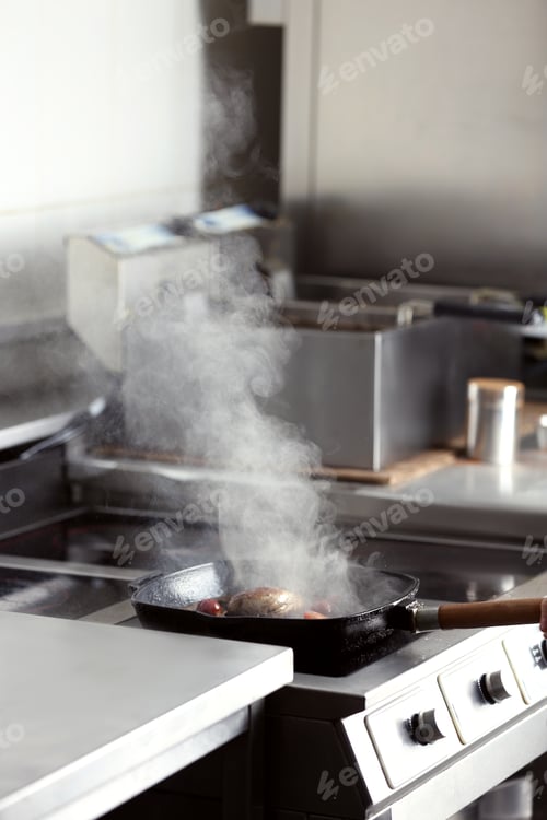 Preview: Cooking delicious meat on frying pan in restaurant kitchen