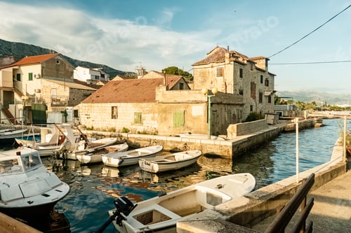 Preview: Serene Adriatic Sea with moored boats alongside the fortress of Kastel Gomilica
