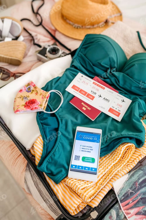 Preview: Open suitcase with woman luggage for beach vacation and covid passport