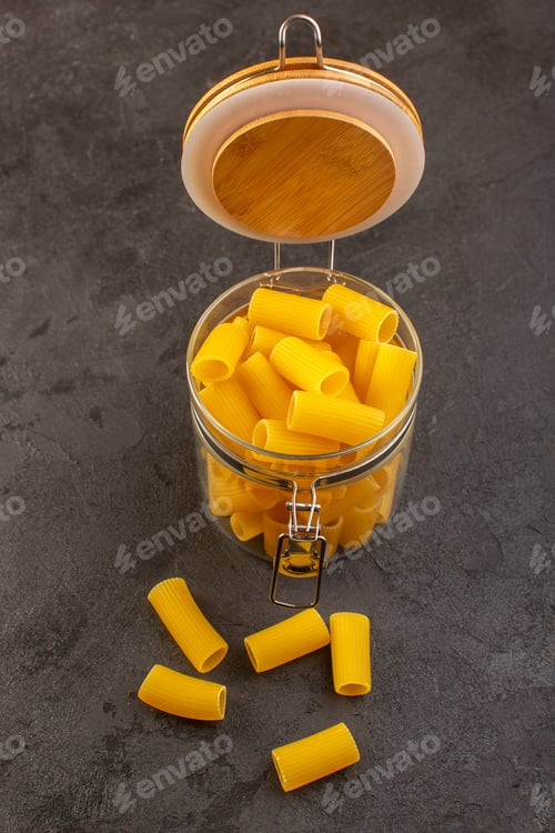 Preview: a front view italian dry pasta yellow raw inside bowl isolated on the dark background italian pasta
