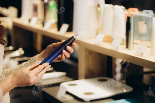 Preview: a woman buys an electric toothbrush in an electronics store