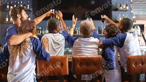 Preview: Rear View Of Friends Wearing Team Colours Watching Game In Sports Bar Celebrating