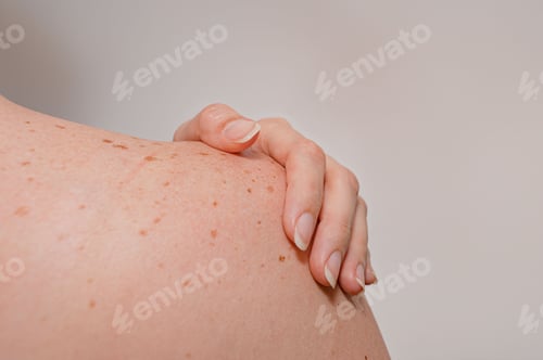 Preview: Closeup shot of the woman's torso from behind with her hand on the shoulder.