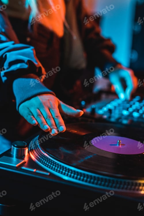 Preview: cropped view of dj woman touching vinyl record in nightclub