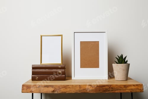 Preview: books near cactus in pot and frames on wooden table