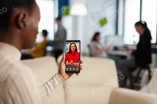 Preview: Over the sholder of black employee discussing with partner on video call