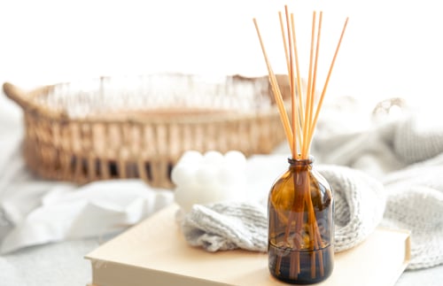 Preview: Spa composition with incense sticks and knitted element on a blurred background.