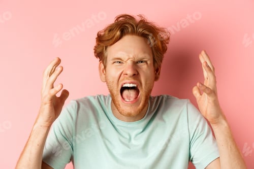 Preview: Face of angry redhead man shouting and shaking hands furious, staring outraged and cursing, express