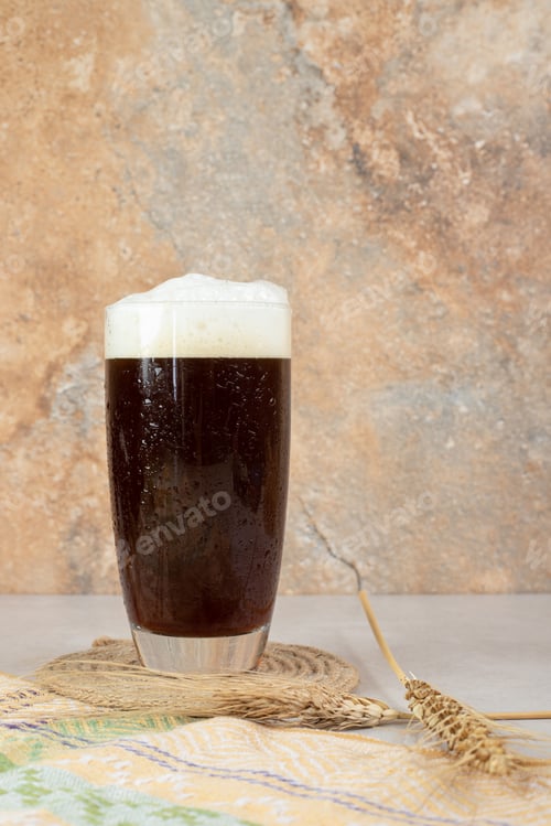 Preview: Glass of dark beer with ears of wheat