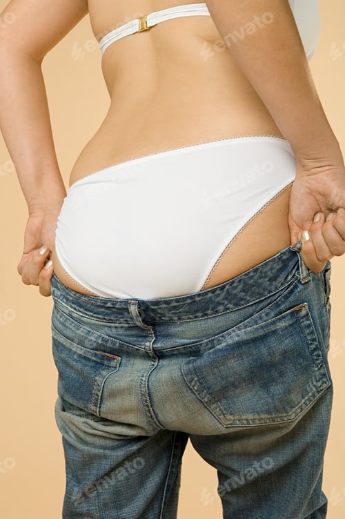 Preview: Woman putting on jeans