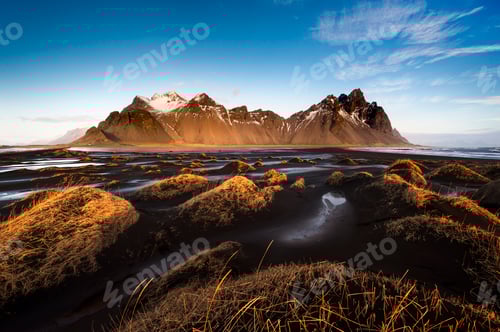 Preview: Sunset gracing the majestic mountain peaks with golden hues