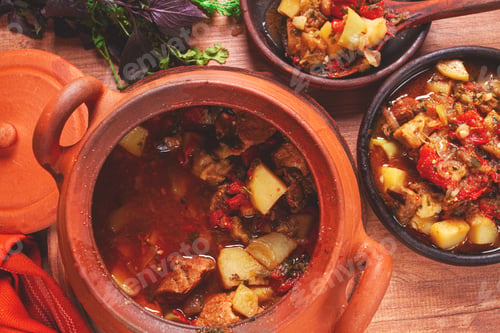 Preview: Chanakhi, a Georgian dish. in a clay pot, on a wooden table, stewed meat with vegetables, homemade,