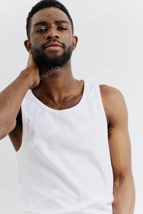 Preview: Young man in white tank top holding head in distress, expressing stress or headache in minimalist