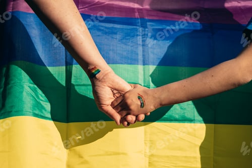 Preview: A mother holding hands with her daughter in the background the gay pride flag, lgtb concept