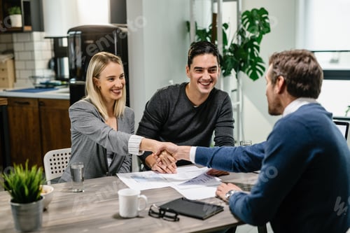 Preview: Happy couple making an agreement with real estate agent during the meeting.