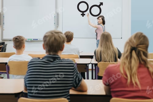 Preview: Young teacher is standing in front of the blackboard during sex education lesson