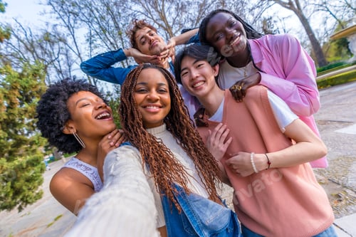 Preview: Friends joking while taking a selfie in an urban park