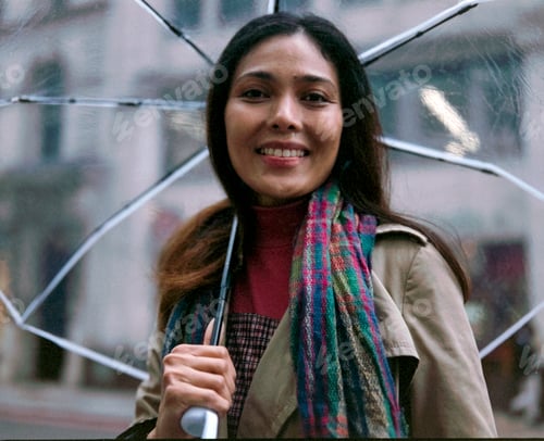 Preview: Philippine woman smiling while holding umbrella in city