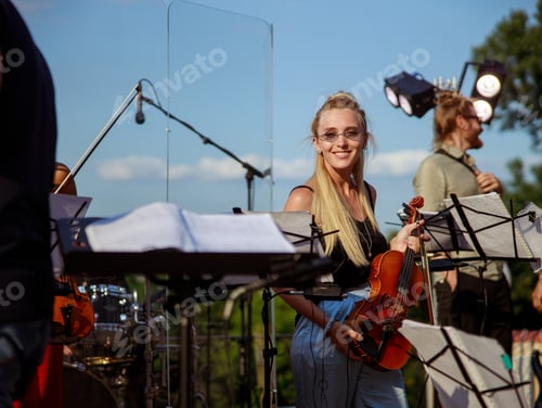 Preview: Cheerful young woman with violin standing on the street