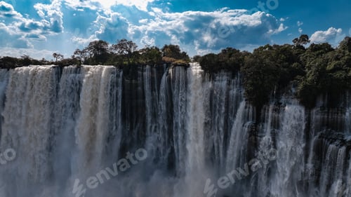 Preview: Stunning view of Kalandula Waterfall cascading in Angola under a bright blue sky