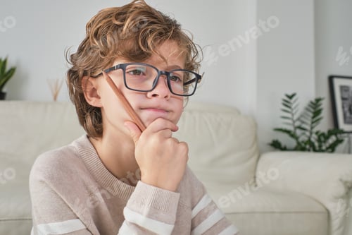 Preview: Puzzled boy in glasses looking at screen