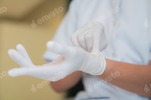 Preview: Doctor or nurse putting on nitrile protective gloves. Medical white hand glove